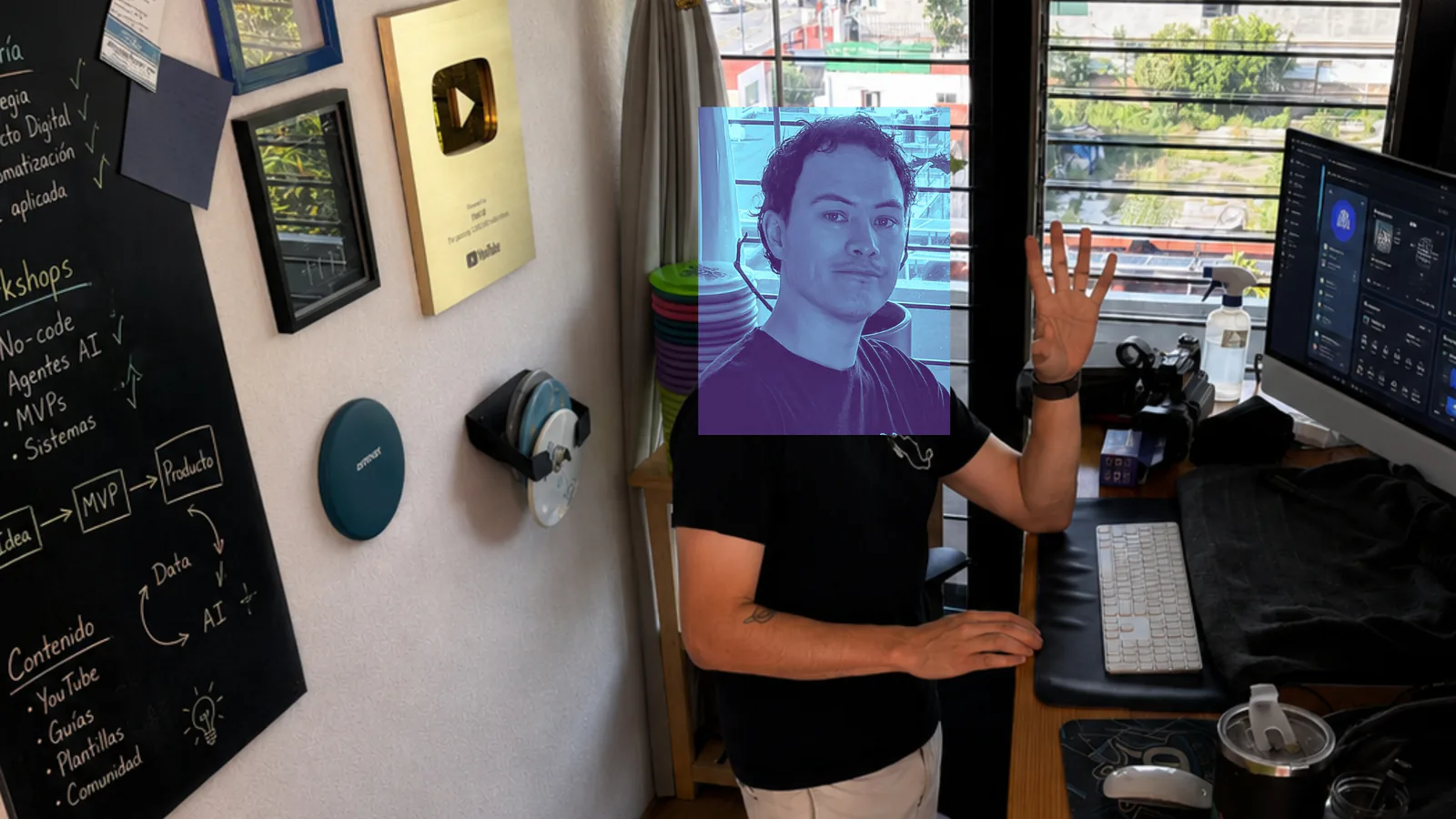 Fabián Oloarte in his studio with a YouTube creator award and a board of content and education notes.
