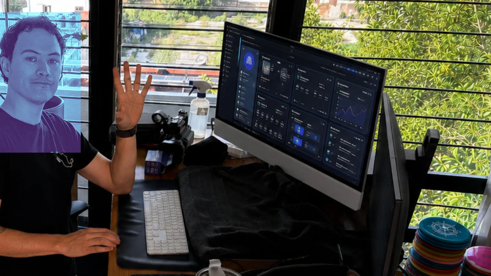 Fabián Oloarte beside a product interface on his iMac in his digital product-building workspace.